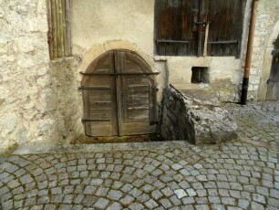 Kirchhof im Nordwesten-Steingaden (innenseitig an die Kirchhofmauer angebaut) mit Eingang zum Keller im Detail