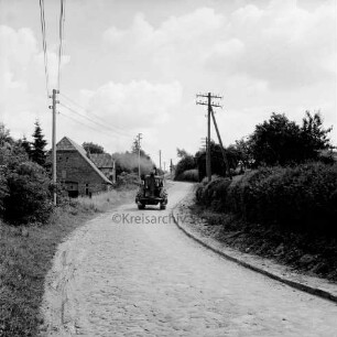 Groß Barnitz: Klein Barnitzer Straße mit Kopfsteinpflaster: hinten Mitte Trecker: rechts und links Hecken: links hinten Bauernhäuser