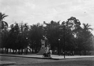 Denkmal in Limeira : Ein Denkmal vor einem Park und Kinderspielplatz in Limeira. Im Park befinden sich zahlreiche Personen.