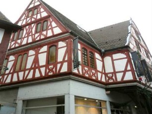 Stadtbild - Freihof im Westen - Giebelständiges Haus mit vorkragenden Obergeschossen in Fachwerk auf Holzstützen querab in Übersicht