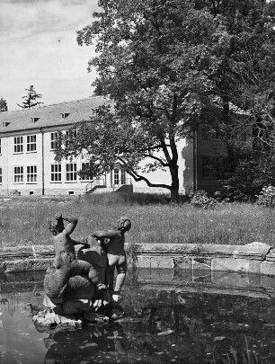 Neschwitz, Parkstraße 12. Neue Schule (1951/1953). Teilansicht der Parkseite. Blick über den Brunnen (Teilansicht) mit Wasserspiel