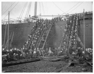 Nagasaki. Einheimische Frauen und Männer beladen den Hochseepassagierdampfer "Cleveland" mit Kohle (transportiert in Körben)