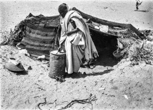 Mann der Berber : Ein Mann der Berber trägt eine Tonne zu seinem Zelt.