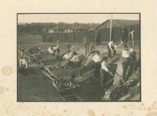 16 Kriegsgefangene mit Spitzhacken und Schaufeln bei Erdarbeiten (Geländebegradigung) im Ausseneinsatz, zwei Wachhabende, Kriegsgefangenenlager Ludwigsburg-Eglosheim