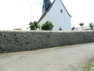 Evangelische Kirche-Ansicht von Westen mit Kirche (Gotische Gründung 15 Jh) mit Dachturm über Kirchhofmauer (Wehrgang mit Steinbrüstung und Schießscharten abgetragen)