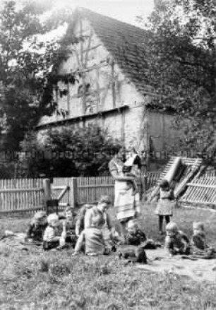 Arbeitsmaiden des Reichsarbeitsdienste bei der Kinderbetreuung, Lager im Garten
