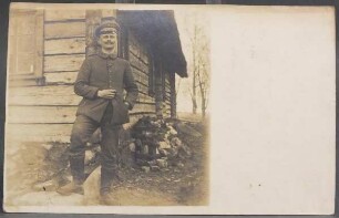 Feldpostkarte: Soldat Alfred Geyer vor Holzhaus