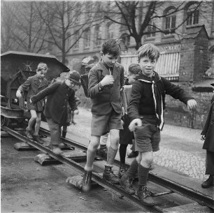 Berlin. Schulkinder balancieren auf den Schienen eines "Trümmerbahn"-Gleises