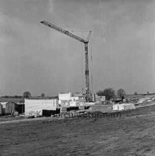 Fritz-Reuter-Straße: Neubaugebiet: vorn Baustelle mit Grundmauern, Baubuden, Baumaterial und Baukran: dahinter Wiesen, Büsche und Bäume: hinten rechts Mühle in Wolkenwehe