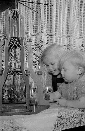 Zwei Kinder vor einer Weihnachtspyramide