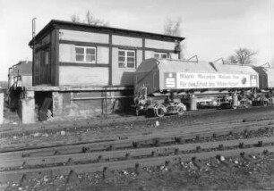 Mügeln. Güterbahnhof. Vierachsiger Schüttgut-Transportwagen (mit Werbeaufschrift der Sparkasse zum Erhalt des "Wilden Robert") der Kaolinwerke Kemmlitz. Ansicht über die Gleise
