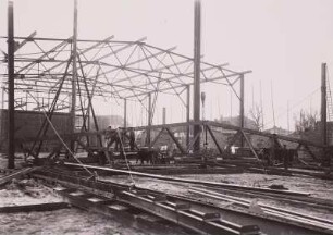 Güstrow. Bau der Versammlungs- und Ausstellungshalle. Bauarbeiter bereiten ein Stahltragewerksegment am Boden zur Montage vor