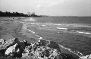 Mangalia: Strand, Vordergrund Steine, Hintergrund Hochhäuser im Badeort Jupiter