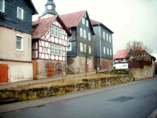 Evangelische Pfarrkirche - Ansicht von Nordosten mit Resten der Kirchhofmauer (Kellereingänge 18 Jhd) sowie neuzeitlich errichtete Gebäude in giebelständiger Manier