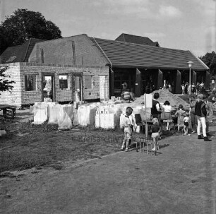 Tremsbüttel-Dorf: Gemeindezentrum: Mehrzweckhalle: Kinderfest: links Erweiterungsbau mit Bühne und Nebenräumen: fertige Grundmauern: davor Baumaterial: rechts Kindergruppe beim Spiel vor Halle