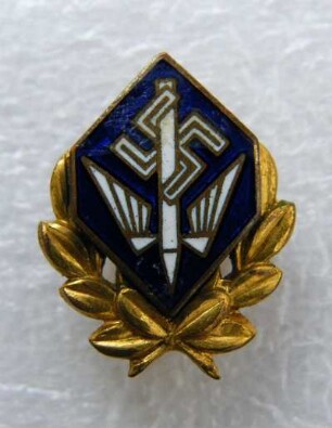 Ehrenabzeichen mit halbem Goldkranz Deutsche Stenografenschaft (mit Broschennadel) : Sammlung Beinhorn. Ehrenabzeichen mit halbem Goldkranz Deutsche Stenografenschaft (geflügelte Feder und Hakenkreuz auf blauem Grund, mit Broschennadel; rückseitig: Ges. Gesch.). Email, Metall, vergoldet; Maße 19 x 15,5 mm (1933/1943). Dresden: SLUB R c 0181