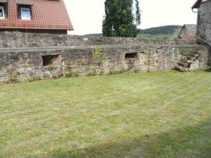 Kirchhof im Norden-Kirchhofmauer mit Schießscharten in Brusthöhe sowie Wehrgang (mit Steintreppe)-Steinbrüstung nicht mehr original hoch (hölzerner Laufgang fehlt)