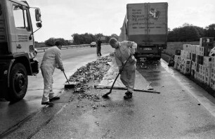 Bundesautobahn 1: Auffahrt Reinfeld Richtung Lübeck: Verkehrsunfall: Mitarbeiter der Autobahnmeisterei beim Zusammenfegen von Flaschenscherben: rechts leere Getränkekisten: hinten rechts verunglückter Lkw mit zerrissener Plane: links Kehrmaschine: hinten Mitte zwei Männer und ein Pkw: 26. Mai 2000