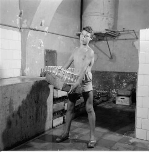 Junger Mann beim Abfüllen von Gassosa (Zitronenlimonade)