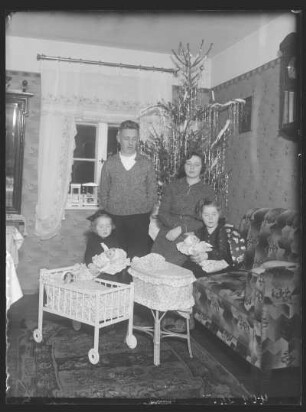 Weihnachten. Familie nach der Bescherung im Wohnzimmer vor dem Weihnachtsbaum