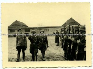 Offiziere schreiten eine Front angetretener Soldaten ab