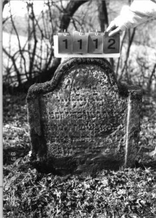 Grabstein 1112 (Index: 99753265) Material: Sandstein Zustand: stark verwitt/großer Textverlust Maße HxBxT: 80x64x10 cm Beschreibung: Stele, eingezogener Rundbogenabschluß, Schriftfeld eingetieft: Grabstein 1112
