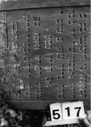 Grabstein 517 (Index: 99802698) Material: Sandstein Zustand: unten abgeblättert/Textverlust Maße HxBxT: 88x50x12 cm Beschreibung: Stele mit verdachtem Rundbogen, profilierter Rand, Giebelfeld: Grabstein 517 (Detailaufnahme)