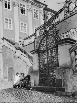 Unbekannter Ort. Junge Frauen auf einer Bank sitzend, an einem Eingang zu einem Schloss?