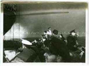 Besatzungsmitglieder in einem vollbesetzten Rettungsboot neben dem untergehenden Hochseepassagierdampfer "Columbus" am 19. Dezember 1939