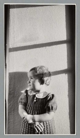 Portrait eines Kleinkindes durch ein Fenster blickend