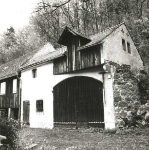 Cossebaude-Niederwartha, Tännichtgrundstraße 18. Alte Hofemühle (1851/1900). Wirtschaftsgebäude mit Toreinfahrt, Ladeluke und ansetzender Bruchsteinmauer