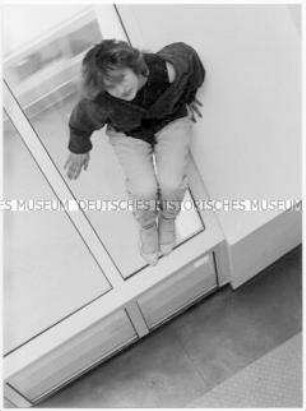 Junge Frau vor einem Fenster (Altersgruppe 14-17)