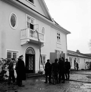 Brand: Haus Lichtensee: Propstei Stormarn: evangelisches Zentrum mit Altersheim und Jugendheim: Dachgeschossbrand des Hauptgebäudes: Vorderfront mit Eingang: davor Feuerwehrmänner mit gerettetem Schrank: Wasserschlauch über Balkon
