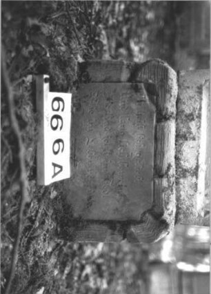 Grabstein 666 (Index: 99900567) Material: Sandstein Zustand: stellenweise verwittert Maße HxBxT: 123x45x18 cm Beschreibung: aufgesockelte Stele mit oben abgeflachtem Dreiecksaufsatz, im Dreiecksfeld Levitenkanne, daneben Eckakroterien, Schriftfeld von Zackenfries umgeben Symbolik: Levitenkanne, Zackenfries Besonderheit: Levitenkanne auf einem Frauengrab ?: Grabstein 666A
