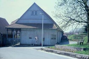 großes Scheunengebäude am Friedhofsweg; auffällig und ungewöhnlich die Betonsteine als Fußwegbegrenzung