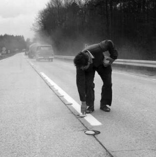 Anbringung der Leitlinien für Umleitungen auf der Autobahn mit aufklebbaren Nägeln ohne Stifte.