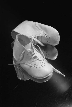 Formalismus. Babylauflernschuhe, auf einem Spiegel stehend