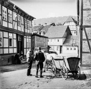 Pferdewagen : Männer neben einem Pferdewagen zwischen Fachwerkhäusern