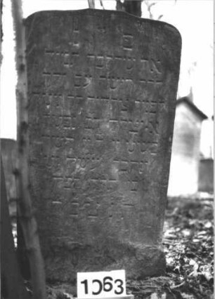 Grabstein 1063 (Index: 99899690) Material: Sandstein Zustand: stark verwittert Maße HxBxT: 115x63x8 cm Beschreibung: Stele mit Flachbogenabschluss: Grabstein 1063 (1)