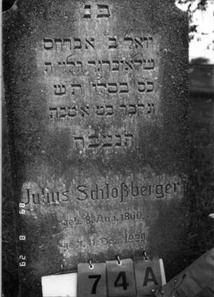 Grabstein 74 (Index: 100108183) Material: Kunststein Zustand: bewachsen Maße HxBxT: 119x50x15 cm Beschreibung: Stele, Abschluß mehrfach konkav gerundet, Sockel: Grabstein 74A