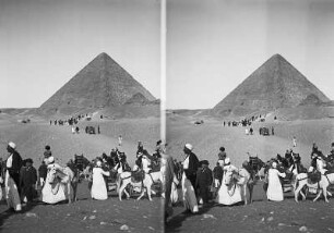 Gizeh (Ägypten). Touristen und Fremdenführer mit Pferden und Kamelen in der Nähe einer Pyramide