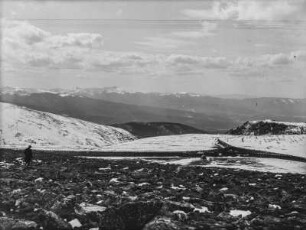 Bergpanorama : Eine Berglandschaft mit verschneiten Gebirgszügen im Hintergrund