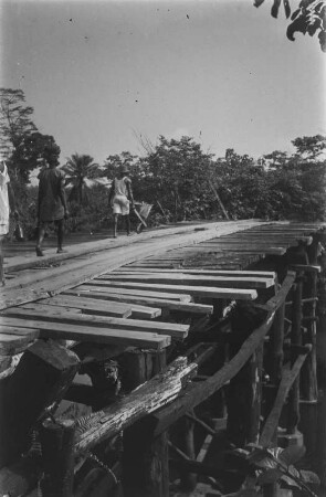 Holzbrücke : Männer auf einer Holzbrücke über einen Fluß bei Kakata.
