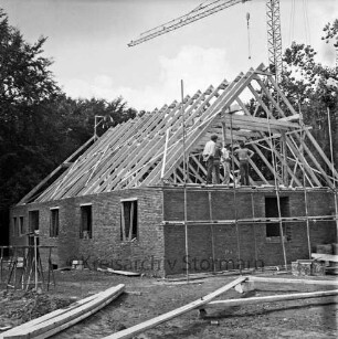 Lütjensee: Seeredder: zweiter Erweiterungsbau: Richtfest: Rohbau mit Gerüsten: auf Dachstuhl Arbeiter und Gäste: links Richtkrone: hinten rechts Baukran: dahinter Bäume