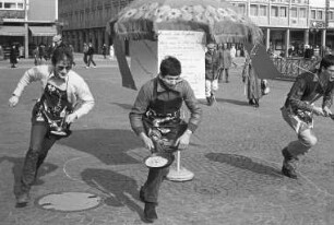Deutsch-englischer Freundeskreis Karlsruhe. Pfannkuchen-Rennen "pan-cake-race" am schmutzigen Donnerstag auf dem Karlsruher Marktplatz