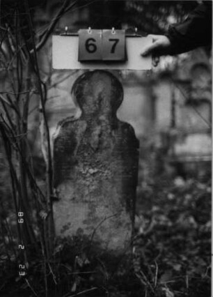 Grabstein 67 (Index: 99751805) Material: Sandstein Zustand: abgeblättert mit großem Textverlust Maße HxBxT: 92x31x10 cm Beschreibung: Stele, geschwungener Abschluß mit Palmette Symbolik: Palmette: Grabstein 67