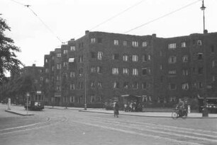 Straßenansicht von Amsterdam : Straßenszene mit Straßenbahn und begrüntem Wohnhaus