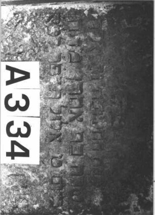 Grabstein 334 (Index: 100082410) Material: Kalkstein Zustand: stark verwittert mit Textverlust Maße HxBxT: 180x200x33 cm Beschreibung: Ädikula mit dorischen Säulen, breiter Sockel, Giebel Symbolik: Kranz mit Schleife, Sterne: Grabstein 334A