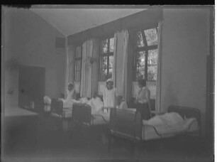 Pflegerinnen mit Patientinnen im Schlafsaal