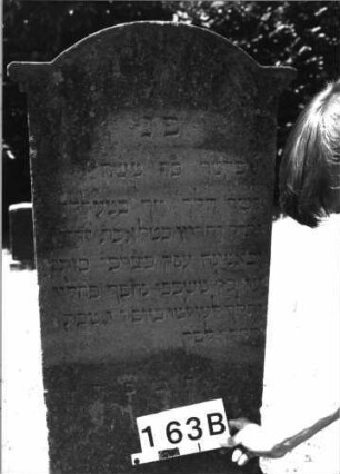 Grabstein 163 (Index: 100085425) Maße HxBxT: 160x51x22 cm Beschreibung: Stele, getrepp. Sockel, eingezog. Rundbogenabschl. m. Verdach. , Schriftfeld eingetieft: Grabstein 163B